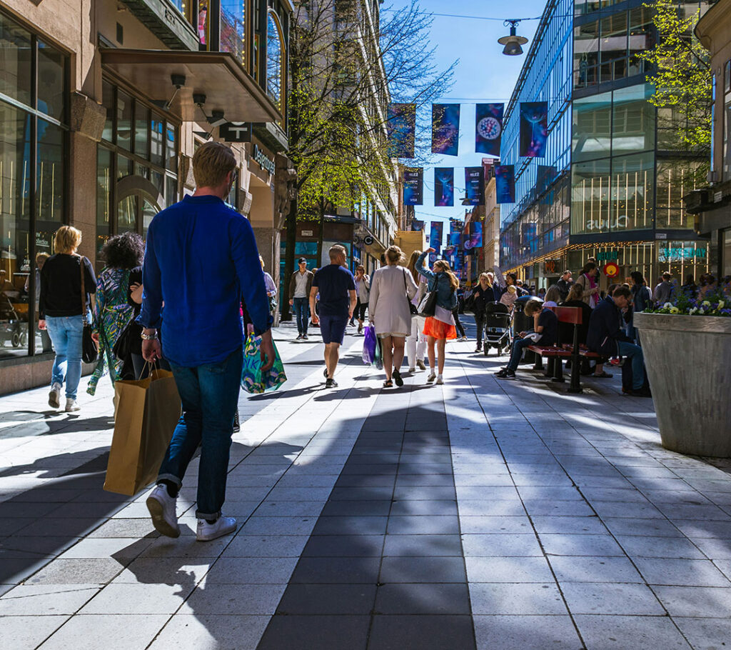 Gågata med folk som promenerar längs butiker.